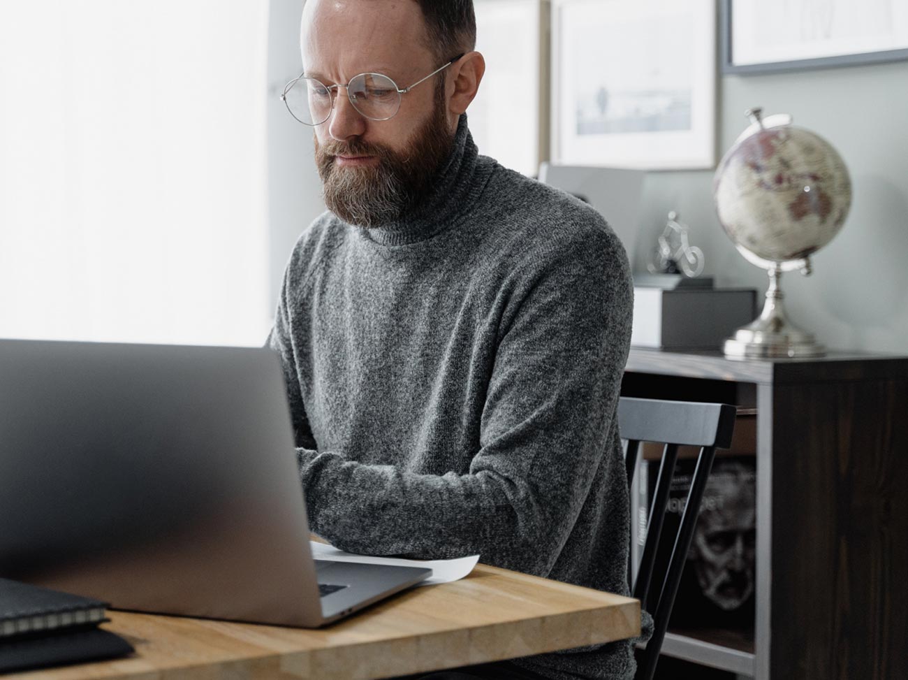 Hombre trabajando con su portátil en su despacho